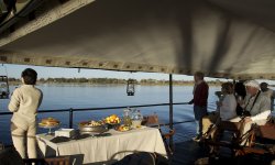 People sitting on deck of Selinda Reserve in Northern Botswana.